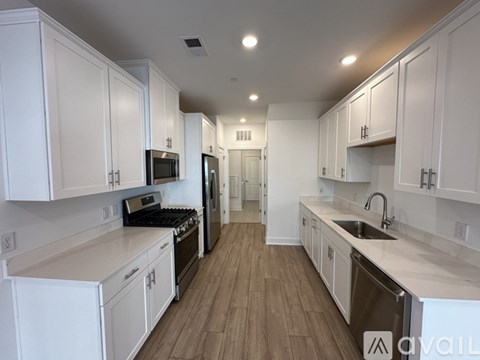 A kitchen with white cabinets and stainless steel appliances.