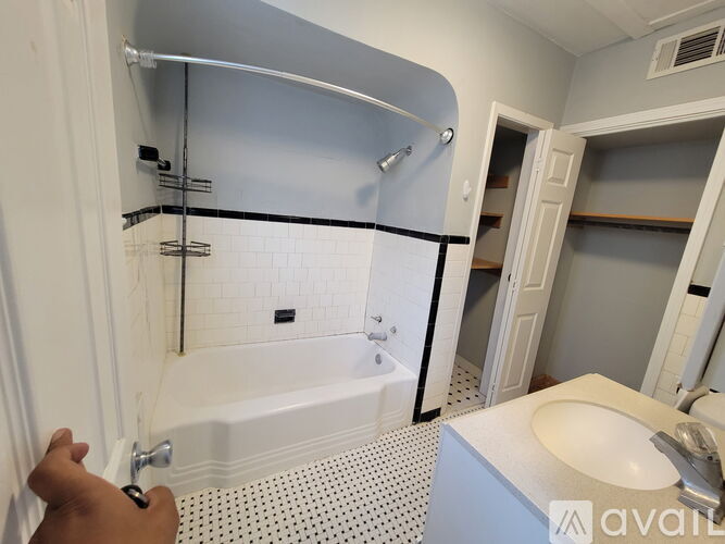 A person is opening a white bathroom door.