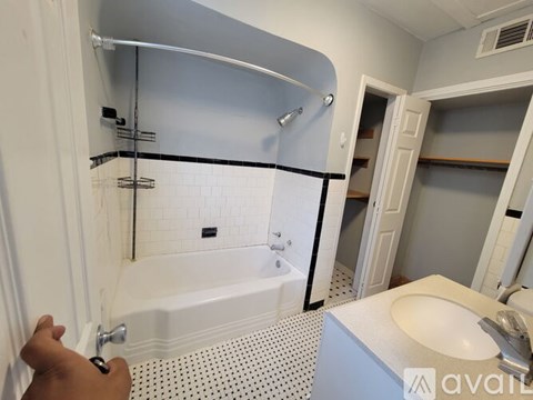 A person is opening a white bathroom door.