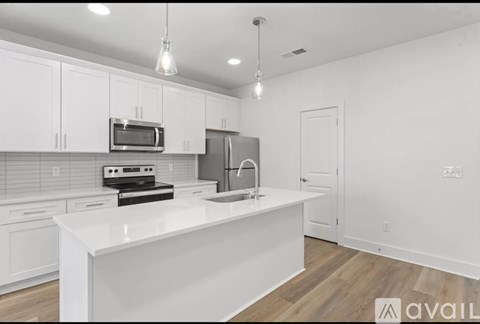 A kitchen with white cabinets and appliances.