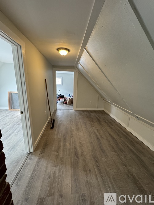 A hallway with wooden floors and white walls.