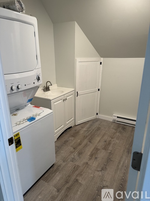 A small kitchen with a white fridge and a white sink.