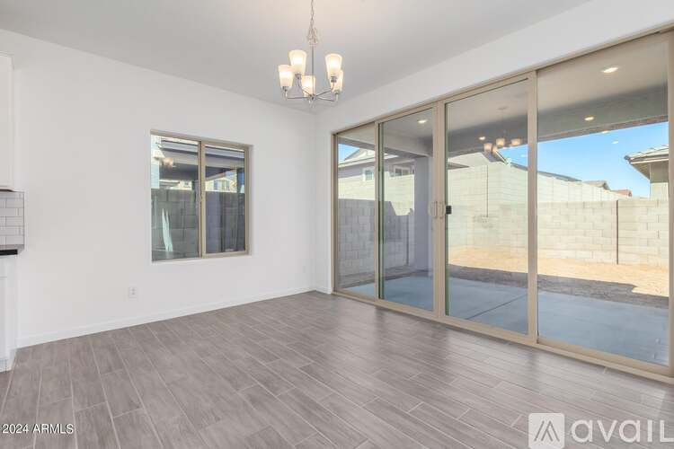 A spacious room with a sliding glass door leading to a balcony.