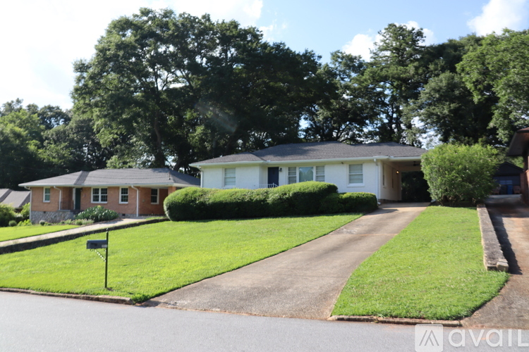 A house with a white fence and green lawn is for sale.