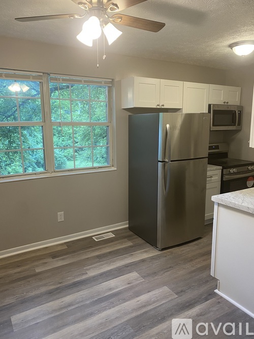 A kitchen with a stainless steel refrigerator and a ceiling fan.