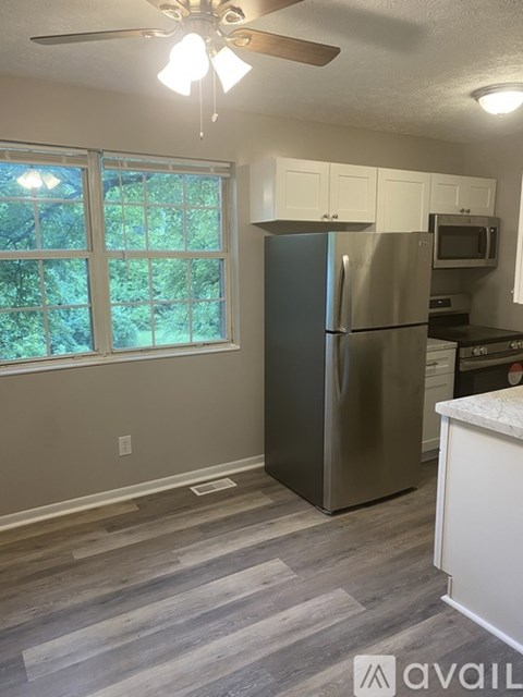 A kitchen with a stainless steel refrigerator and a ceiling fan.