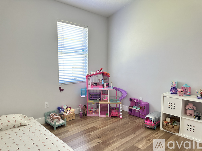 A child's bedroom with a pink bunk bed and toys scattered around.