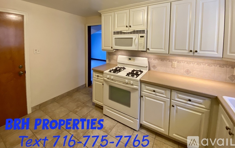 A kitchen with white appliances and cabinets is for sale.
