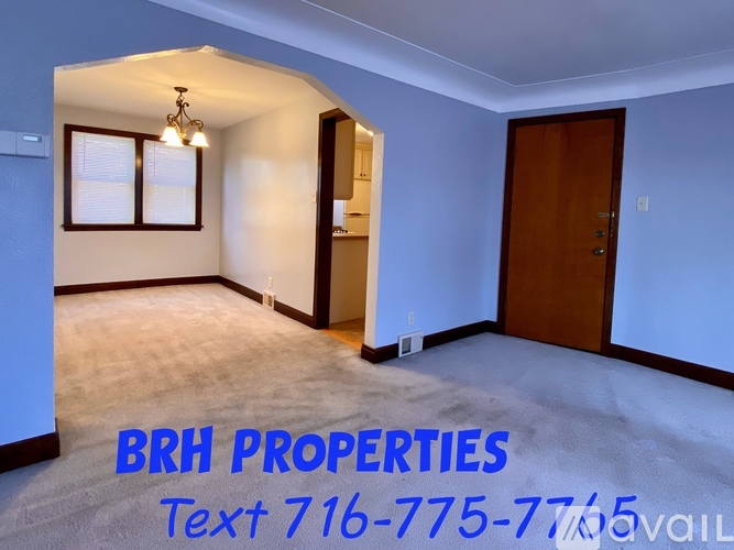 A room with a BRH PROPERTIES sign and a phone number on the floor.