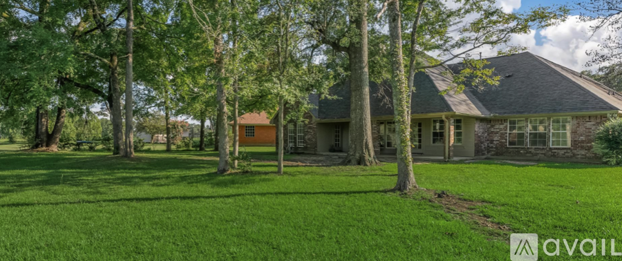 A house with a lawn and trees in front of it.