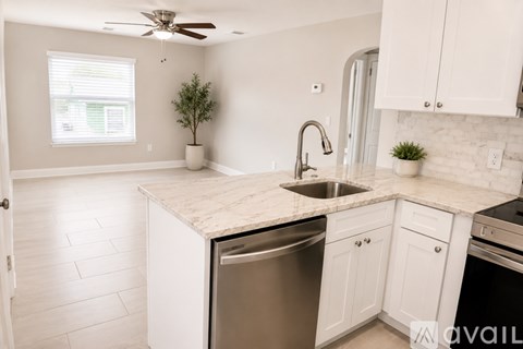 A kitchen with white cabinets and a marble countertop.