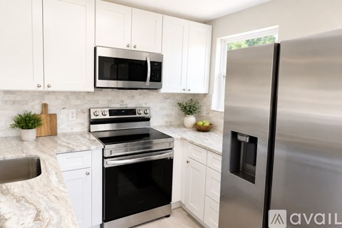 A kitchen with white cabinets and stainless steel appliances.