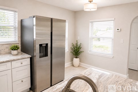 A kitchen with a stainless steel refrigerator and a small potted plant on the counter.
