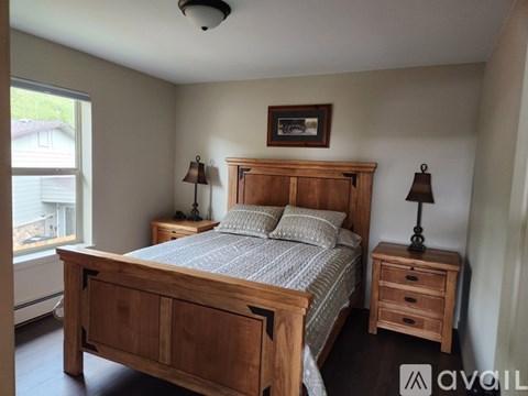 A bedroom with a bed, nightstand, and lamp.