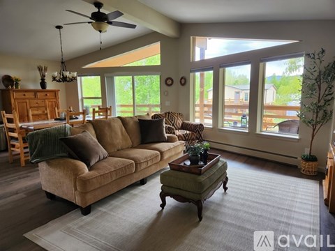 A living room with a couch, a coffee table, and a ceiling fan.