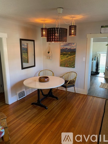 A dining room with a white table and chairs.