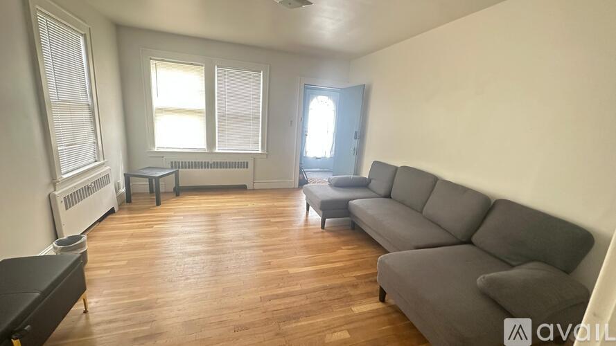A living room with a grey sofa and wooden floors.