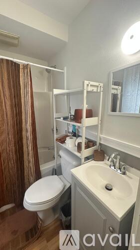 A bathroom with a toilet, sink, and a mirror.