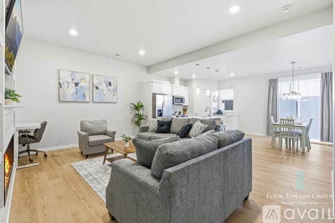 A living room with a grey couch and a fireplace.