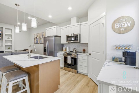 A kitchen with a white counter top and a brown island.