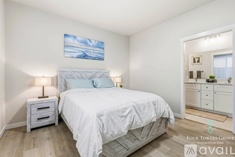A bedroom with a bed, nightstands, and a painting on the wall.