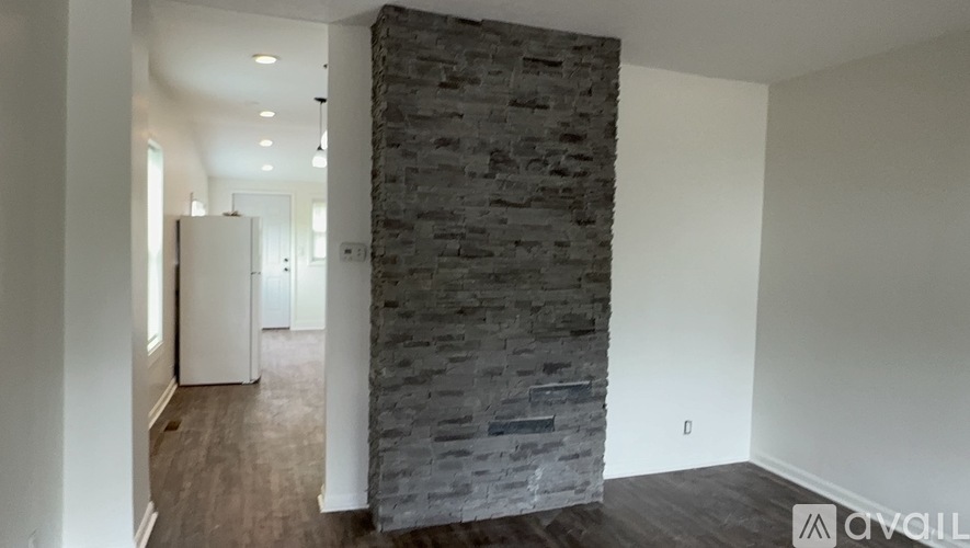 A stone pillar in a room with a white door.