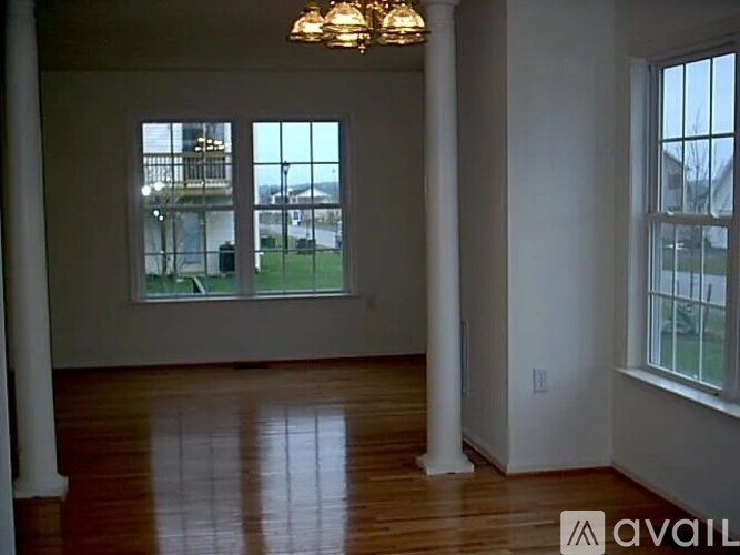 A room with a large window and a wooden floor.