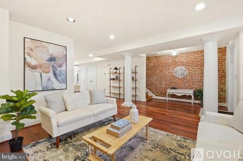 A living room with a white couch and a wooden coffee table.