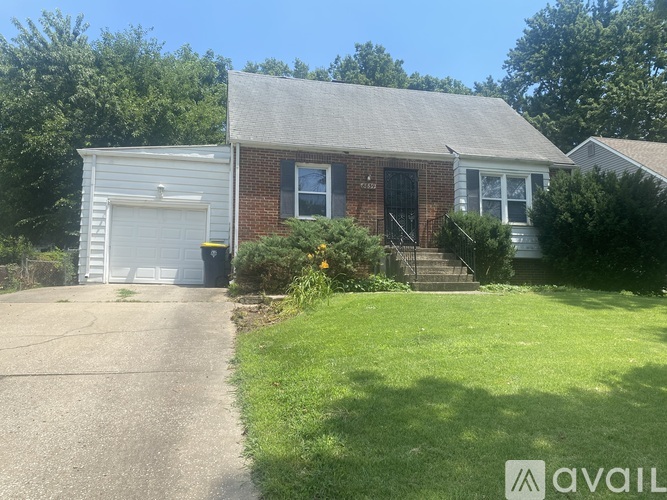 A house with a garage and a driveway in front of it.