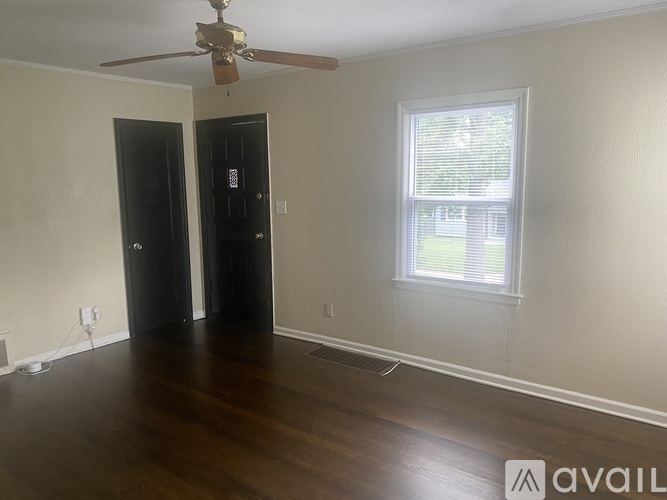 A room with a ceiling fan and two doors.
