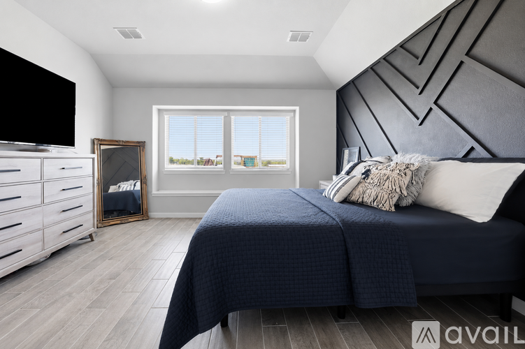A bedroom with a large bed and a flat screen TV.