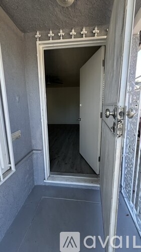 A white door with a silver handle is open to a dark room.