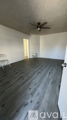 A room with wooden flooring and a ceiling fan.