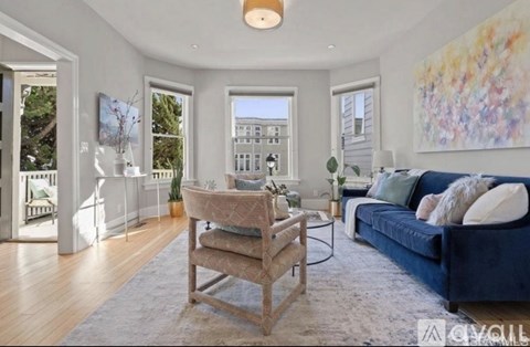 A living room with a blue couch and a wooden chair.