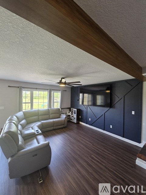 A living room with a white sofa and a wooden ceiling.