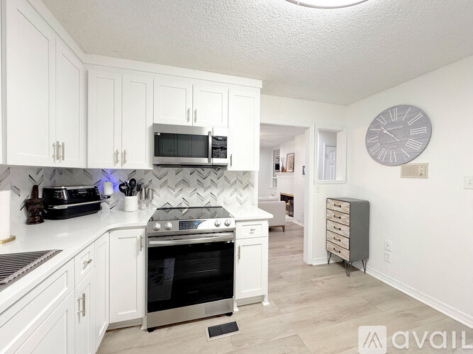 A kitchen with white cabinets and a stainless steel oven.