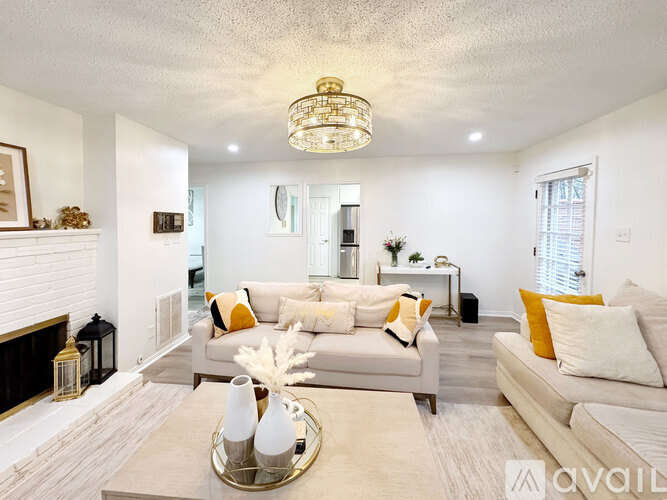A living room with a white couch and a chandelier.