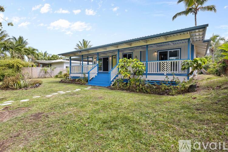 A blue house with a porch and a small garden in front.