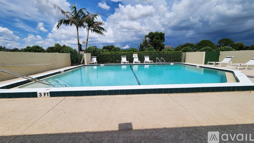 A pool with a depth of 3 feet is surrounded by a concrete floor and a green fence.