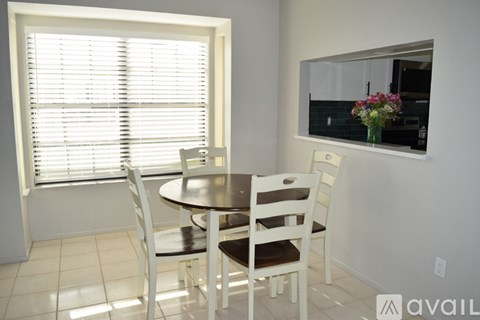 A dining room with a table and chairs.