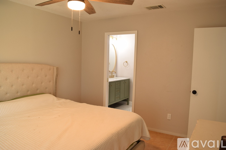 A bedroom with a bed, dresser, and ceiling fan.