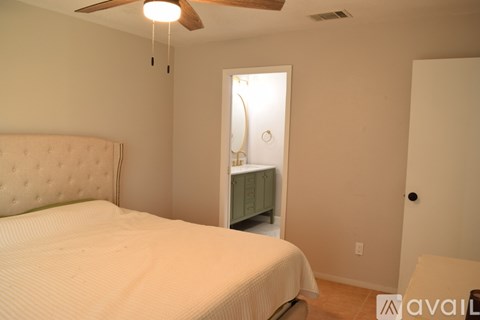 A bedroom with a bed, dresser, and ceiling fan.