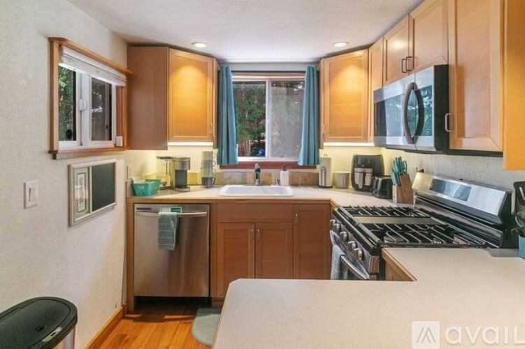 A kitchen with wooden cabinets and a stainless steel dishwasher.
