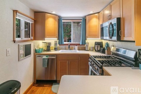 A kitchen with wooden cabinets and a stainless steel dishwasher.