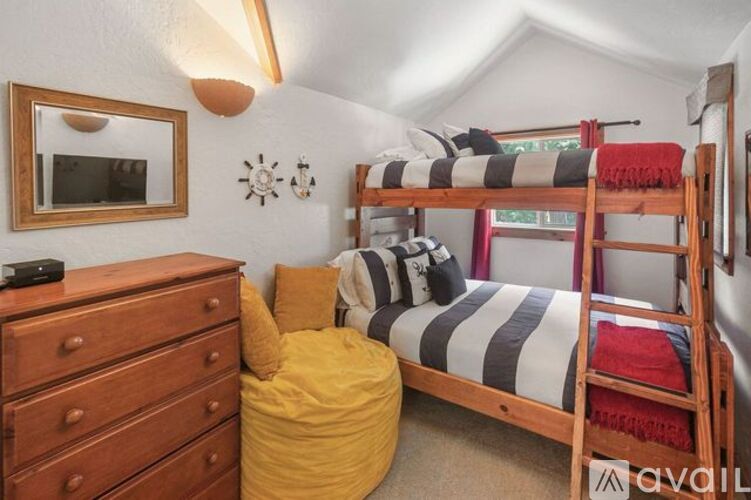 A bedroom with a bunk bed and a dresser.