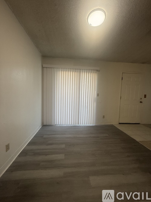 A room with a wooden floor and a white door.