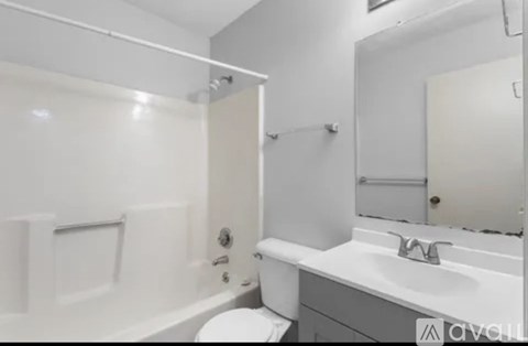 A white bathroom with a toilet, sink, and bathtub.
