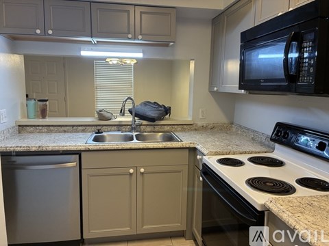 A kitchen with a white countertop and a white stove top oven.