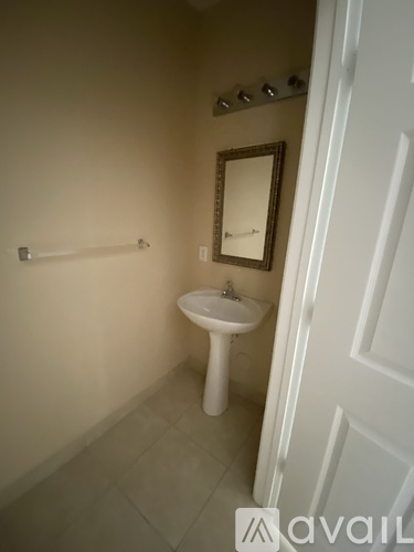 A bathroom with a white sink and a mirror.