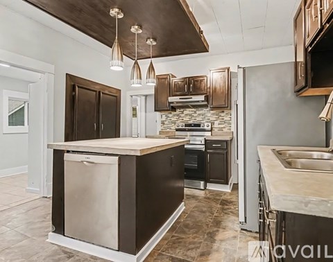 A kitchen with a large island and dark brown cabinets.